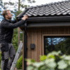 Yrkesperson som granskar villa, tak och trädetaljer.
