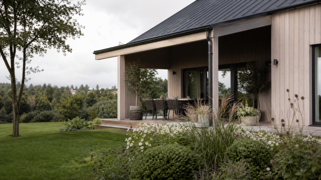 Modern svensk villa med trädgård i lugnt dagsljus.